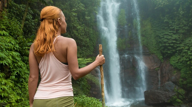 American Eco Tourist in Guyana by a waterfall